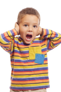 Little boy closing ears with his hands